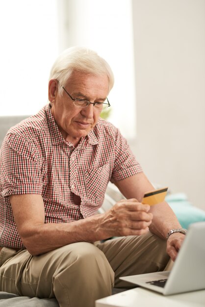 Uomo senior che compera online a casa