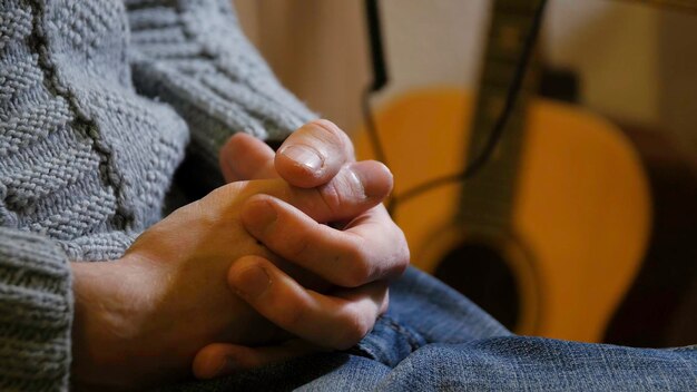 Photo senior man sitting on the chair holding his hands together man sits with fingers crossed