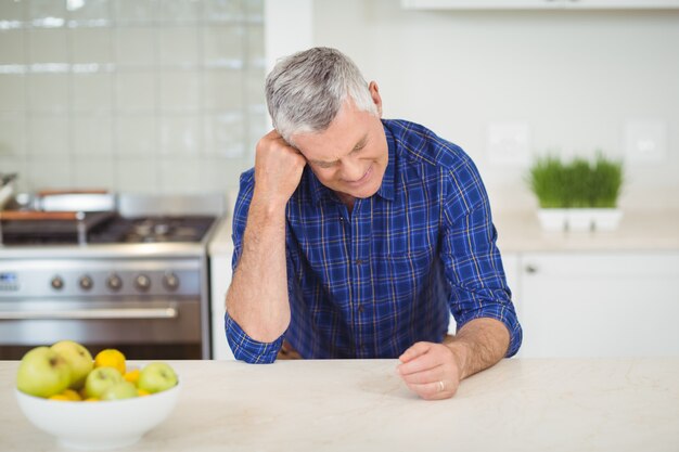 Senior man sitting in kitchen