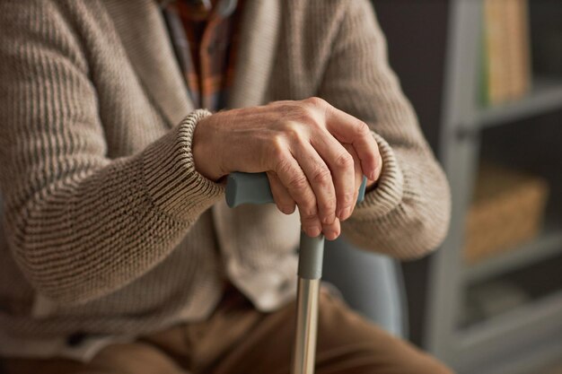 Senior man sitting with stick