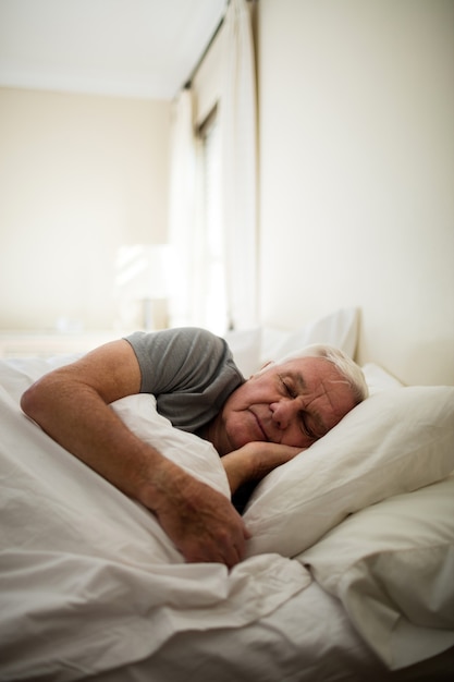 Senior man slapen in de slaapkamer thuis