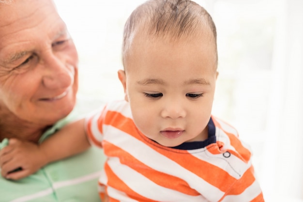 Senior man spelen met zijn kleinzoon thuis