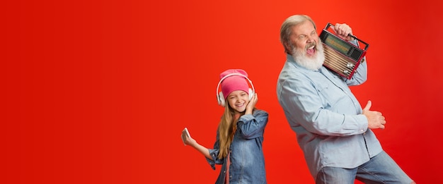 Photo senior man spending happy time with granddaughter on red