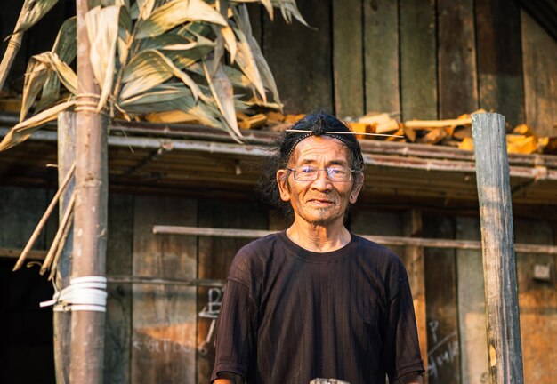 Photo senior man standing against hut