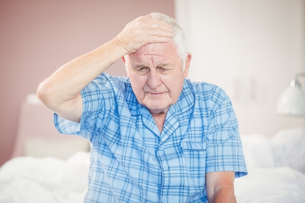 Старший мужчина страдает от головной боли