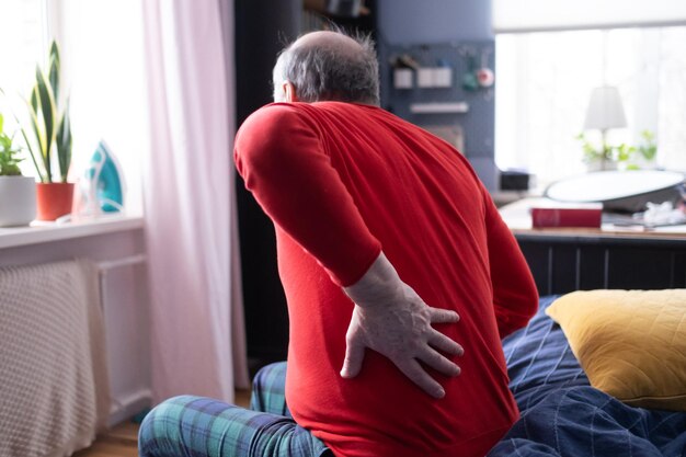 Photo senior man suffering from pain in back or reins at home