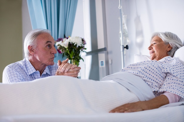 Senior man talking to ill senior patient