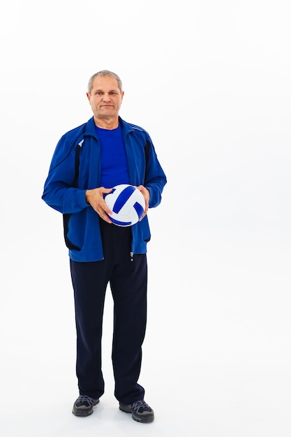 Photo senior man in a tracksuit holds the ball on white