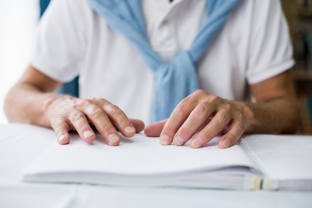 Senior man using braille to read