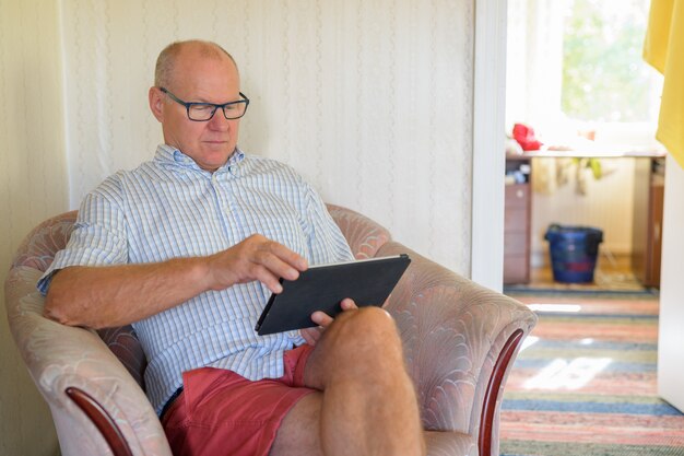 Senior Man Using Digital Tablet In The Living Room