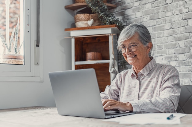 Photo senior man using laptop at home