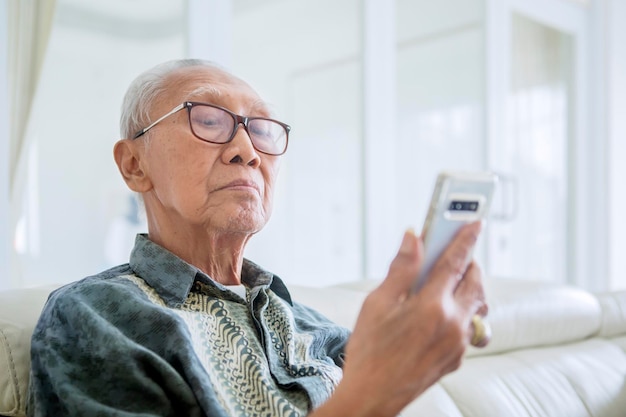 Senior man using a smartphone at home