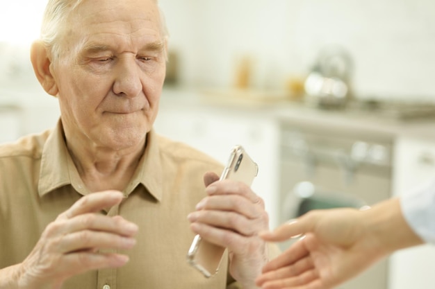 senior man using smartphone while staying home