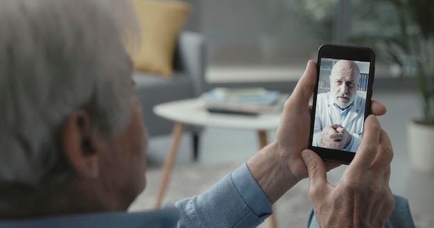 Senior man video calling his doctor