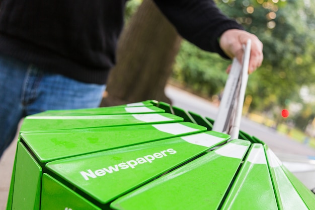 Senior Man Wasting Newspaper in Recycling Basket