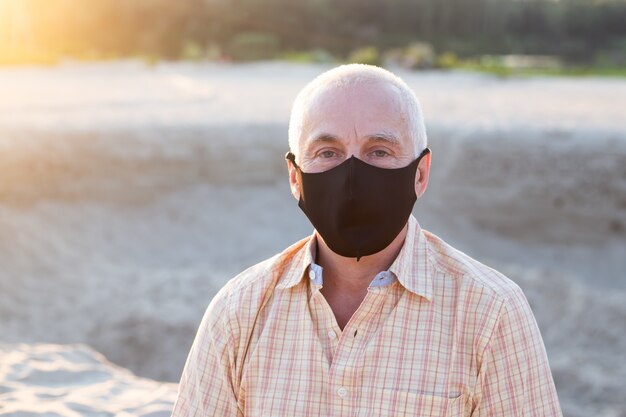 L'uomo senior che indossa la maschera medica si protegge dal concetto medico e di salute di coronavirus ,.