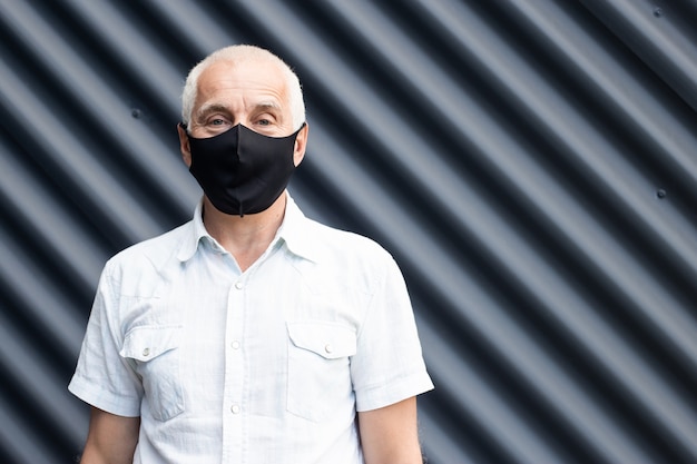 Senior man wearing a protective medical mask, place for text, copyspace