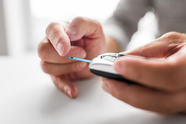 senior man with glucometer checking blood sugar