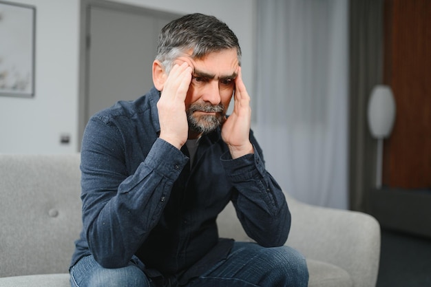 Senior man with headache at home