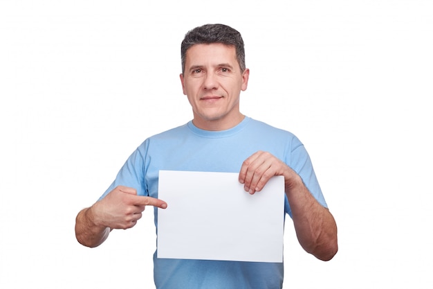 Фото Старший человек с улыбающееся лицо, держа чистый лист бумаги и делая жест, указывая пальцем на него.