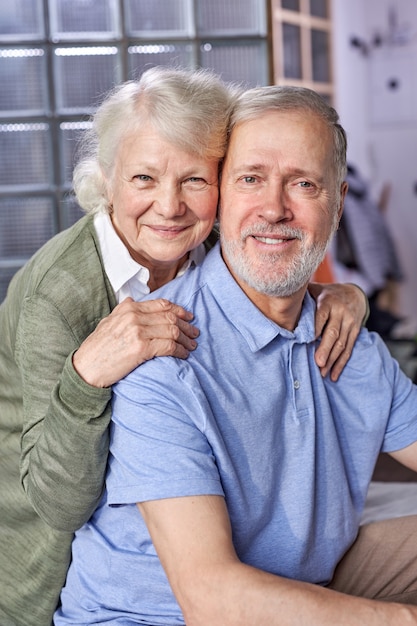 Photo senior man and woman looking at camera smiling, posing at home, leisure time at weekends, happy retirement. portrait