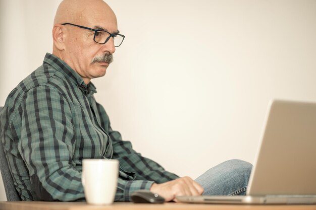 Senior Man Working with Laptop at Home