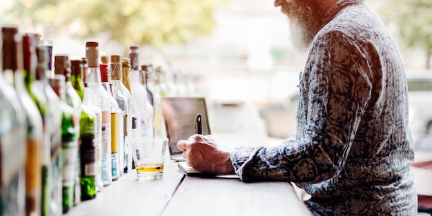 Foto concetto di alchohol antivari di lavoro del liquore di scrittura dell'uomo senior