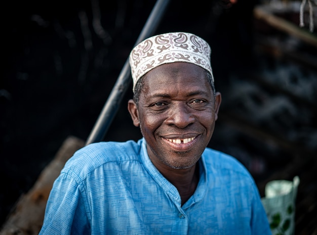 Senior man zittend aan de kust lachend mooi met hoed van hoge kwaliteit foto