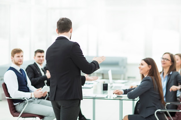 Старший менеджер компании проводит рабочую встречу с бизнес-командой в современном офисе.
