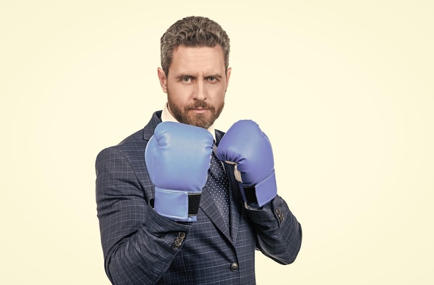 Senior manager stand in fighting position wearing boxing gloves in business formalwear challenge