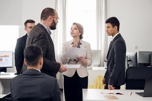 Senior managers en stagiaires houden een bijeenkomst in het witte kantoor van het HR-bedrijf. Open ruimte zone. Meerdere mensen