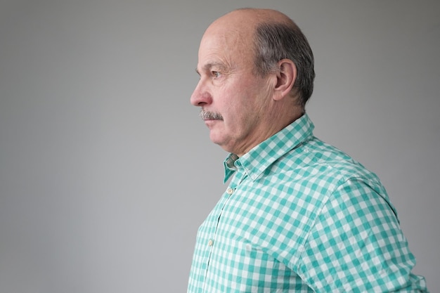 Senior mature hispanic man looking aside with ni emotions on face