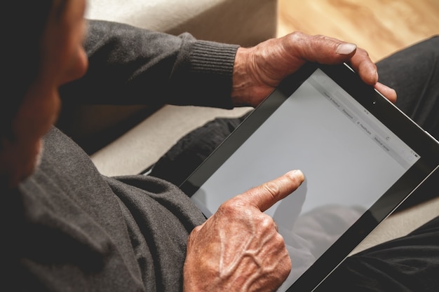 Senior met een tablet in handen