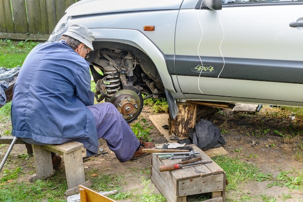 Senior monteur vervangt het voorwiel van het voertuig