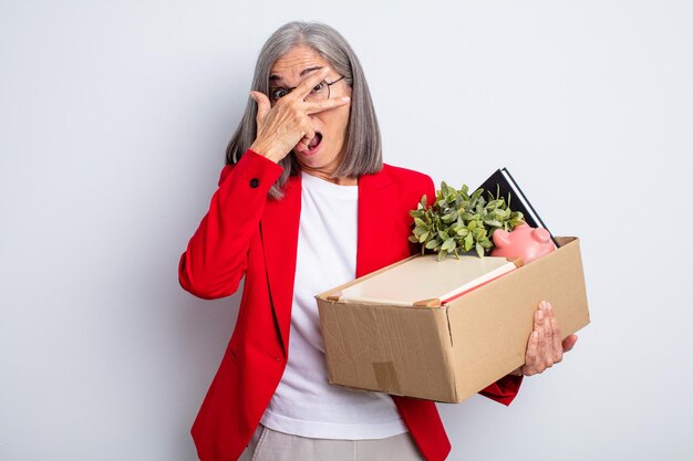 Senior mooie vrouw die geschokt, bang of doodsbang kijkt en haar gezicht bedekt met de hand. ontslag concept