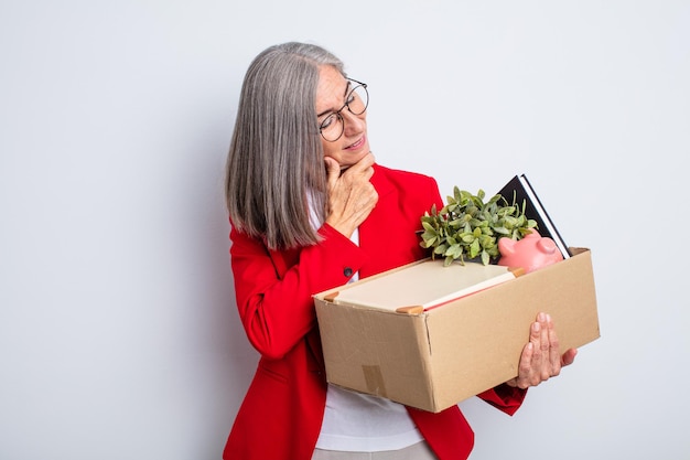 Senior mooie vrouw die lacht met een vrolijke, zelfverzekerde uitdrukking met de hand op de kin. ontslag concept