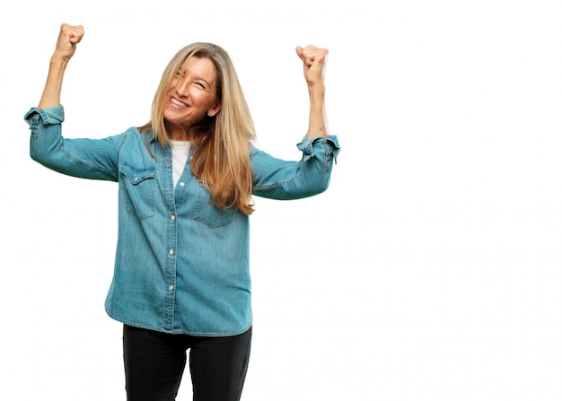 Senior mooie vrouw Gesturing overwinning, met een gelukkige, trotse en tevreden blik op het gezicht en beide ar