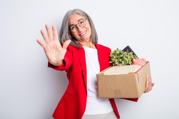 Senior mooie vrouw lacht en ziet er vriendelijk uit, met nummer vijf. ontslag concept