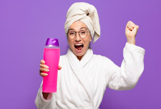 Senior mooie vrouw na douche badjas dragen