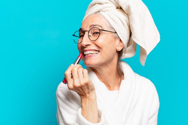 Senior mooie vrouw na het douchen make-up en het dragen van badjas