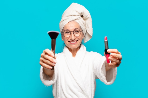 Senior mooie vrouw na het douchen make-up en het dragen van badjasrob