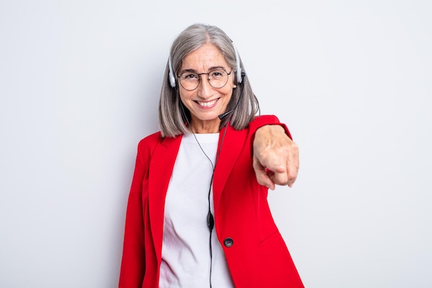 Senior mooie vrouw wijzend op de camera die jou kiest. telemarketeer concept