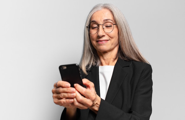 Senior mooie zakenvrouw met een slimme telefoon.