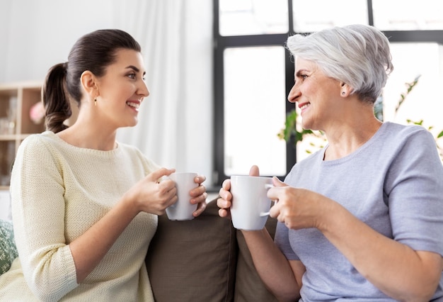 高齢の母親と大人の娘がコーヒーを飲んでいる