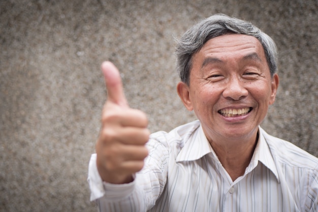 Photo senior old man giving thumb up gesture