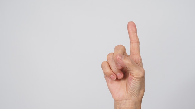 Senior or older woman is doing one finger or point up hand sign on black background.