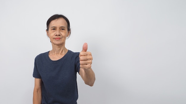 노인 또는 나이든 여성의 손은 흰색 바탕에 손 기호를 좋아하거나 엄지손가락을 치켜들고 있습니다. 그녀는 아시아인입니다.