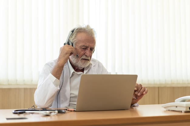 Senior oude dokter draagt headset. Online medische chat-consultatie op afstand, telegeneeskunde-afstandsdiensten. Telegezondheidsconcept