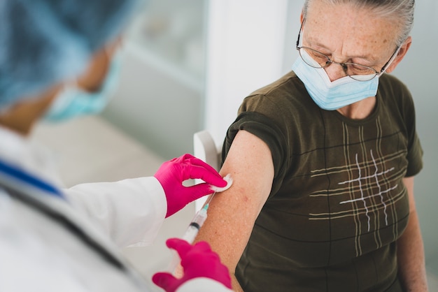 Senior oude vrouw in het ziekenhuis vaccin krijgen