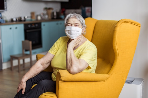 senior oude vrouw in masker quarantaine Europa. Ouderen met risico op coronavirus covid-19. Blijf thuis. Chinese virus longontsteking pandemische bescherming grootmoeder. gevaar om besmet te raken